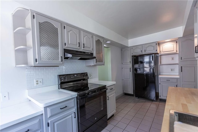 kitchen featuring black appliances, under cabinet range hood, open shelves, light tile patterned floors, and light countertops
