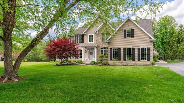 20 Woodthrush Trl, Orchard Park, NY 14127 - view of front of house with a front lawn, stone siding, and roof with shingles