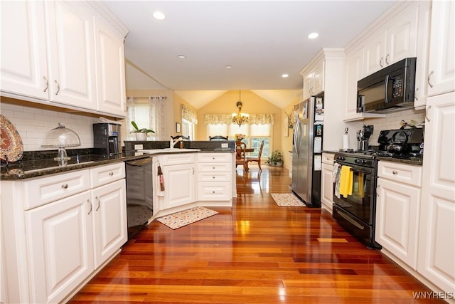 5067 William St, Lancaster, NY 14086 - kitchen featuring black appliances, a peninsula, a chandelier, dark wood finished floors, and plenty of natural light