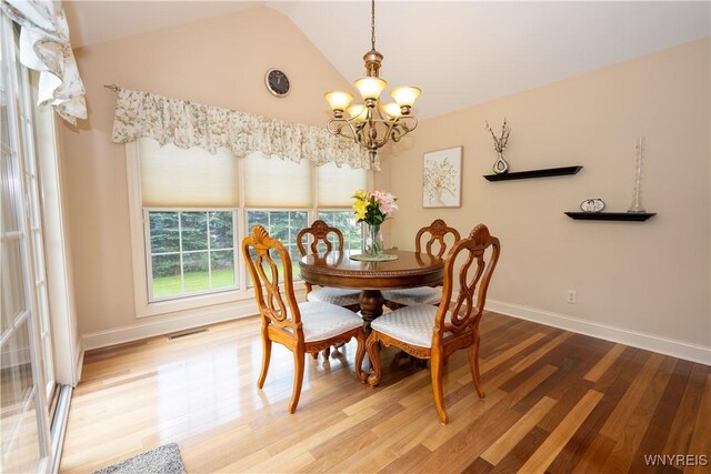 5067 William St, Lancaster, NY 14086 - dining space with a chandelier, wood finished floors, baseboards, and high vaulted ceiling