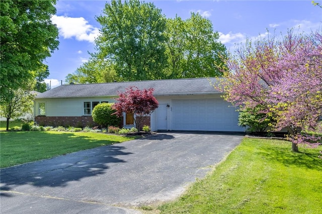 view of front of property with a garage, driveway, a front lawn, and brick siding