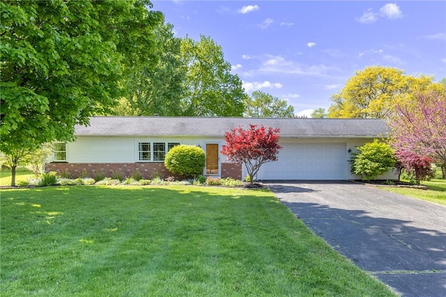 view of front of property featuring brick siding, an attached garage, driveway, and a front yard