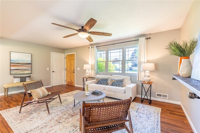 living area featuring wood finished floors, ceiling fan, and baseboards