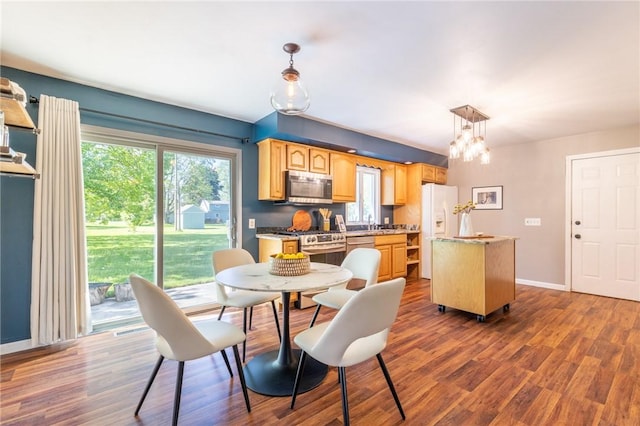 dining area featuring dark wood finished floors, baseboards, and a chandelier