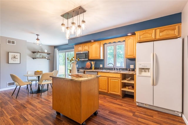 kitchen with white refrigerator with ice dispenser, stainless steel microwave, open shelves, a center island, and light stone counters
