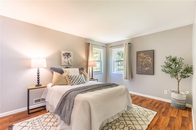 bedroom with baseboards and wood finished floors