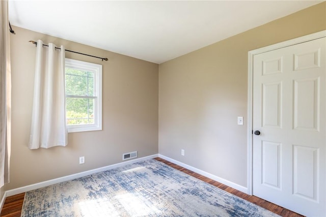 empty room featuring baseboards and wood finished floors