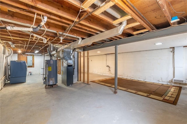 unfinished below grade area with water heater, heating unit, electric panel, and concrete block wall