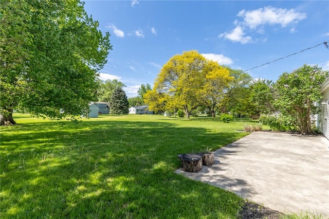 view of green lawn with a patio