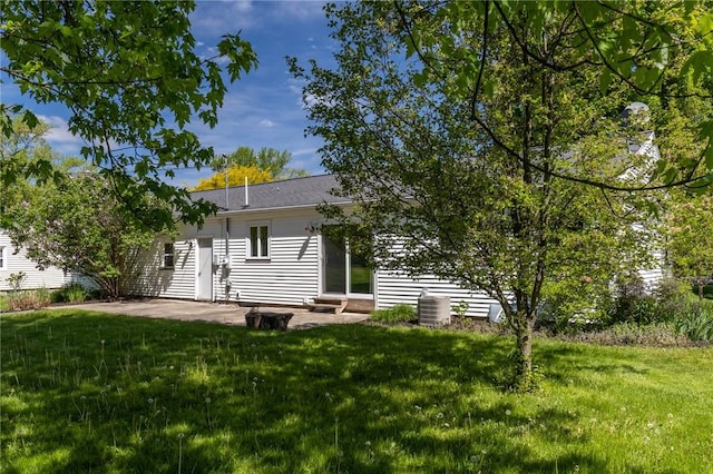 rear view of property with a patio area, a lawn, and cooling unit