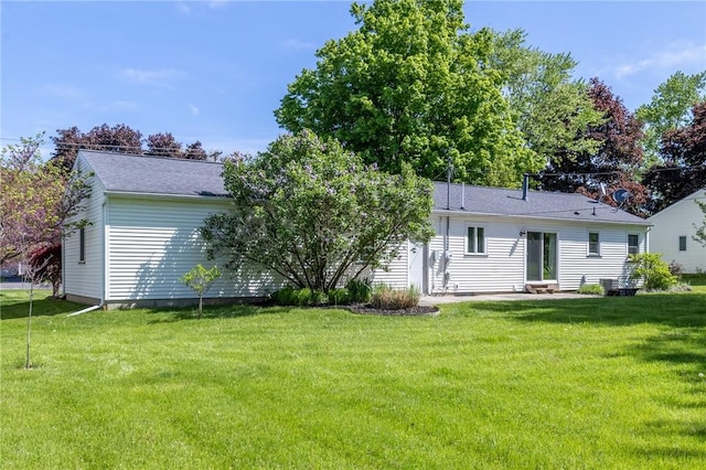 back of property with a lawn, a patio area, entry steps, and a shingled roof