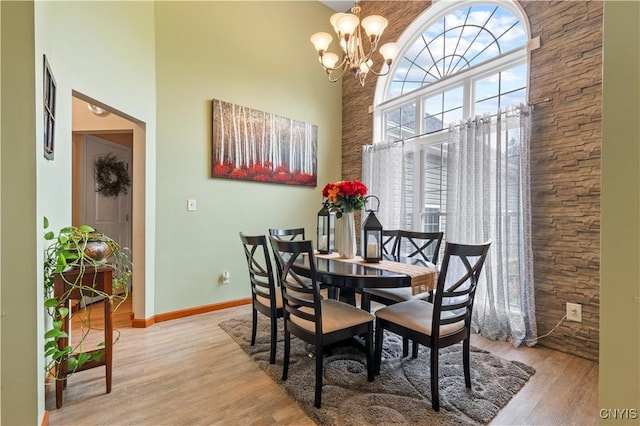 1210 Lake Rd, Oneida-Outside, NY 13421 - dining space with a towering ceiling, a chandelier, light wood finished floors, and baseboards
