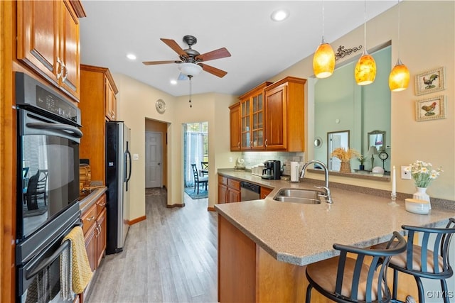 1210 Lake Rd, Oneida-Outside, NY 13421 - kitchen with a sink, brown cabinets, freestanding refrigerator, ceiling fan, and a breakfast bar