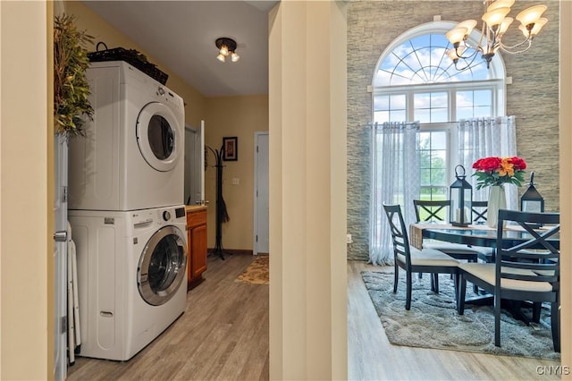 1210 Lake Rd, Oneida-Outside, NY 13421 - washroom with stacked washer / dryer, a chandelier, and light wood-style floors