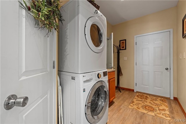 1210 Lake Rd, Oneida-Outside, NY 13421 - laundry room featuring stacked washer and clothes dryer, light wood-type flooring, and baseboards