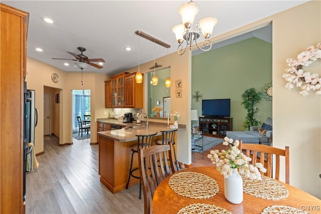 1210 Lake Rd, Oneida-Outside, NY 13421 - kitchen featuring brown cabinetry, a sink, a chandelier, light wood-style flooring, and a kitchen bar