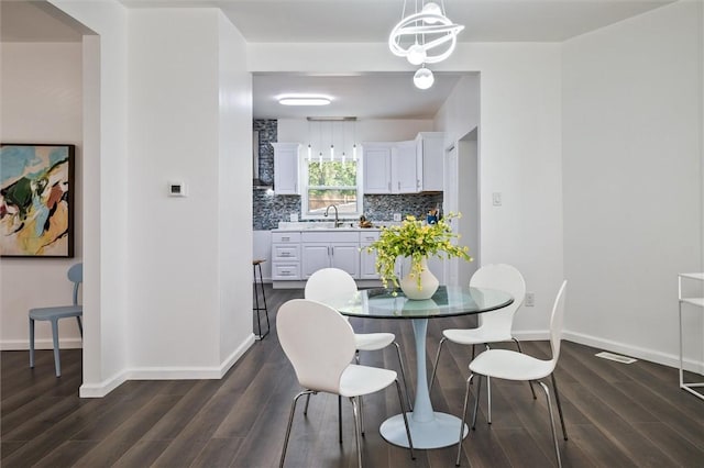 dining space featuring dark wood finished floors and baseboards