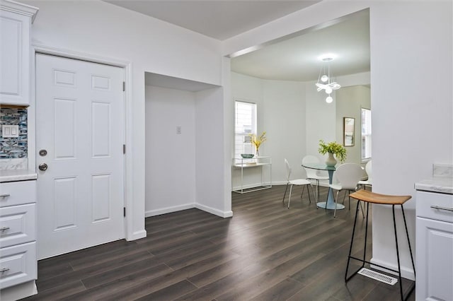 entryway featuring dark wood finished floors and baseboards