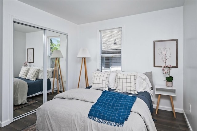 bedroom featuring dark wood finished floors, baseboards, and a closet