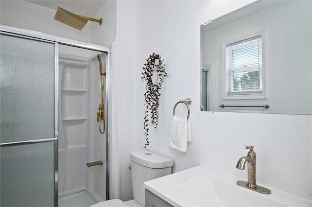 bathroom with a shower stall, toilet, and vanity