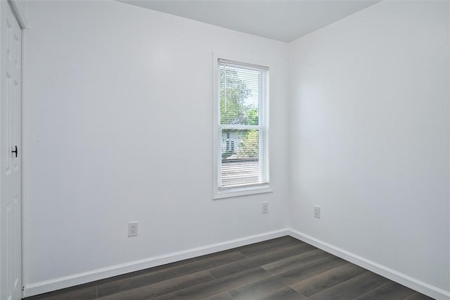 unfurnished room featuring dark wood-style floors and baseboards