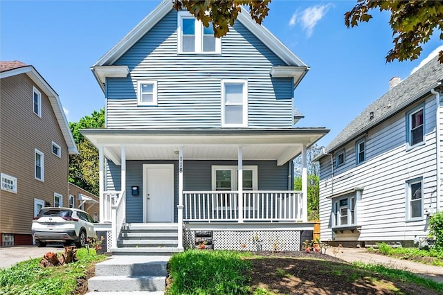 american foursquare style home featuring a porch