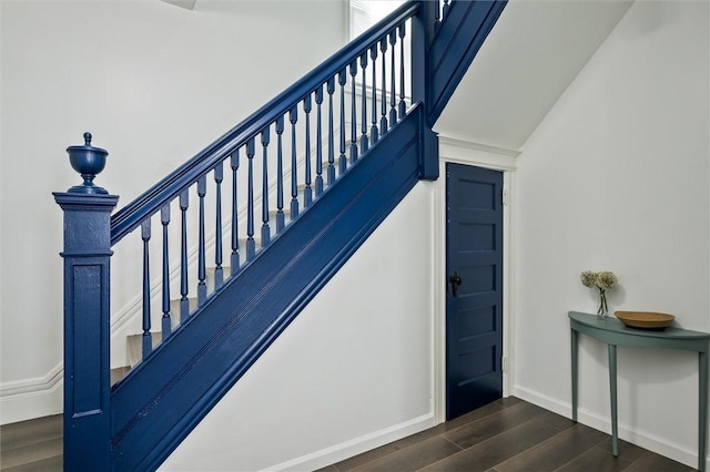 stairway with wood finished floors and baseboards