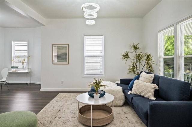 living room featuring wood finished floors, baseboards, and a chandelier