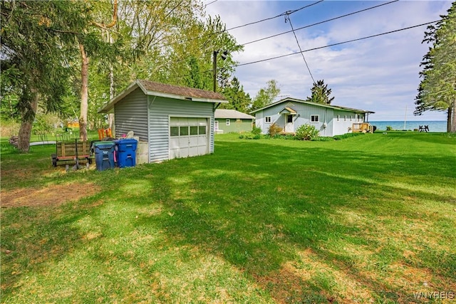 4609 E Lake Rd, Wilson, NY 14172 - view of grassy yard with an outdoor structure, a garage, and a water view