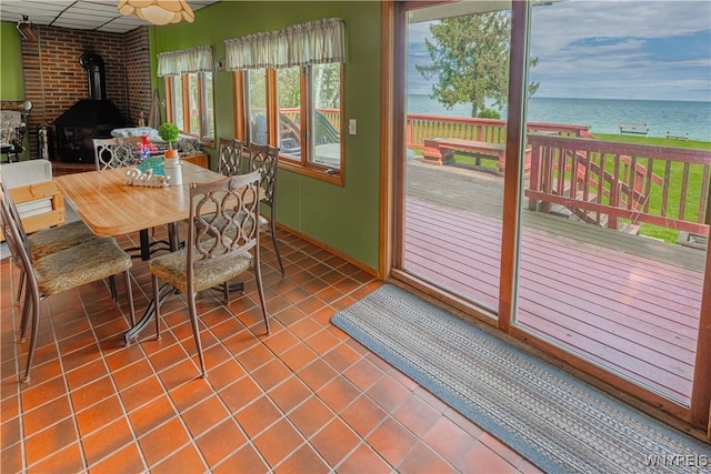 4609 E Lake Rd, Wilson, NY 14172 - sunroom / solarium featuring a wood stove and a water view