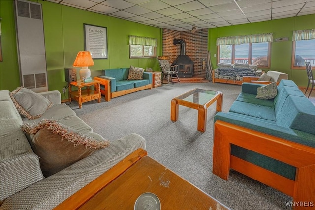 4609 E Lake Rd, Wilson, NY 14172 - carpeted living room with a drop ceiling, a wood stove, and a heating unit