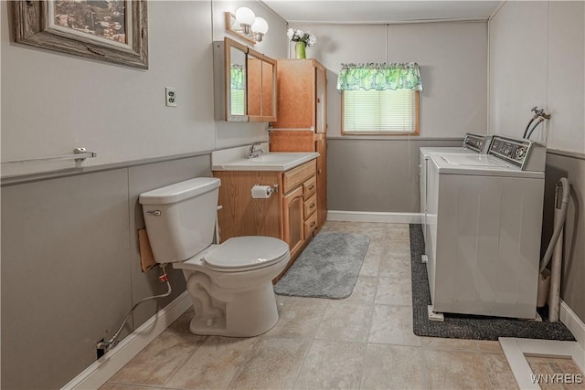 4609 E Lake Rd, Wilson, NY 14172 - bathroom featuring separate washer and dryer, toilet, vanity, baseboards, and tile patterned flooring