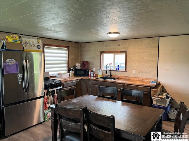319 Ericsson Rd, Poland, NY 14747 - kitchen featuring freestanding refrigerator, a sink, black microwave, wood finished floors, and light countertops