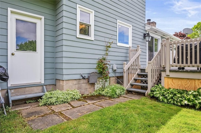 view of home's exterior with a deck, a chimney, and a lawn