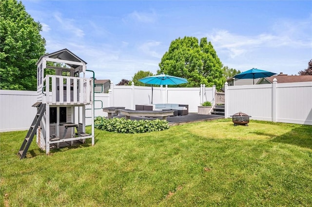 view of yard with a playground and an outdoor living space with a fire pit