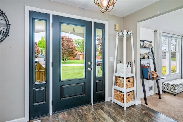 doorway featuring dark wood-style flooring and baseboards