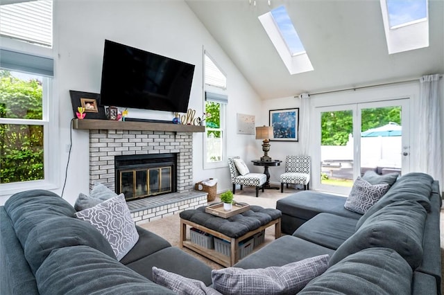 living area with a skylight, high vaulted ceiling, healthy amount of natural light, and a brick fireplace