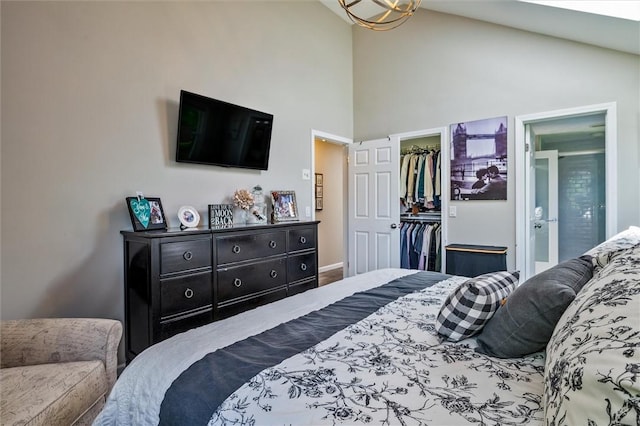 bedroom featuring a spacious closet, a closet, connected bathroom, high vaulted ceiling, and baseboards