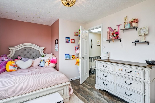 bedroom featuring dark wood-type flooring, a textured ceiling, and baseboards