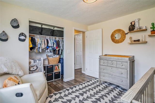 bedroom featuring wood finished floors, a closet, a textured ceiling, and baseboards