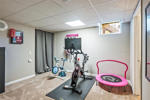 exercise area featuring carpet flooring, baseboards, and a paneled ceiling