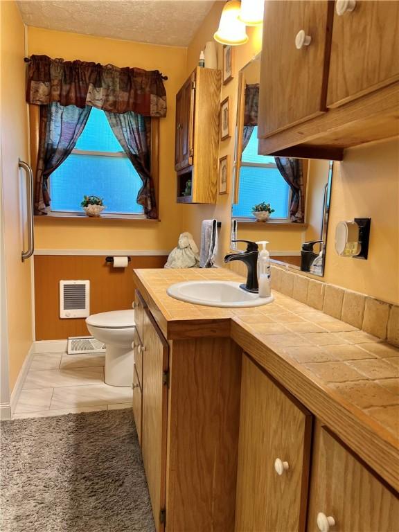 4600 College Ave, Corning, NY 14830 - bathroom with toilet, vanity, and tile patterned floors