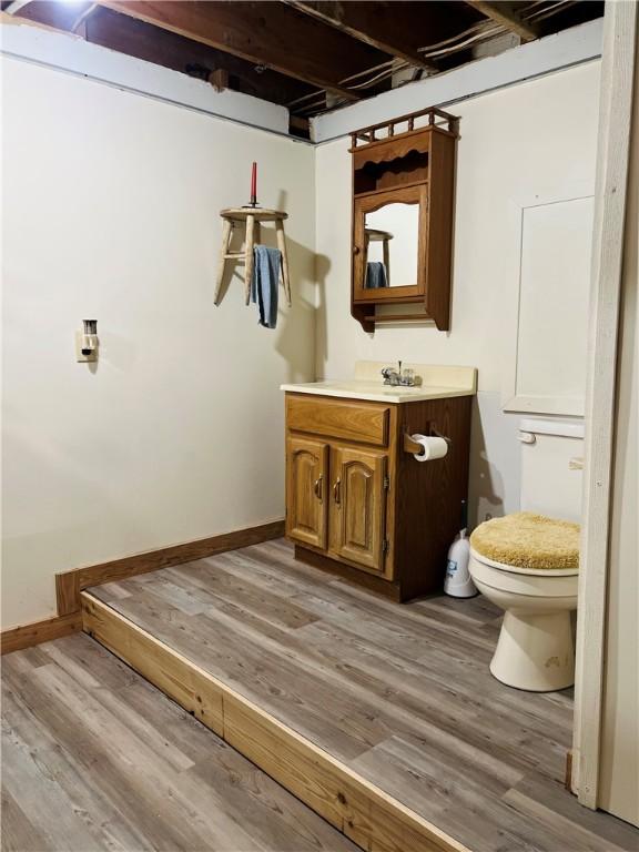 4600 College Ave, Corning, NY 14830 - bathroom featuring wood finished floors, toilet, vanity, and baseboards