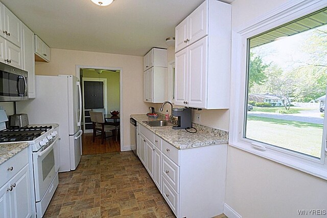 458 Kenwood Dr, Lewiston, NY 14092 - kitchen with appliances with stainless steel finishes, a sink, white cabinets, and baseboards