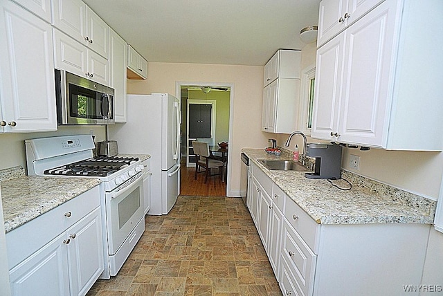 458 Kenwood Dr, Lewiston, NY 14092 - kitchen featuring white appliances, a sink, stone finish flooring, and white cabinets