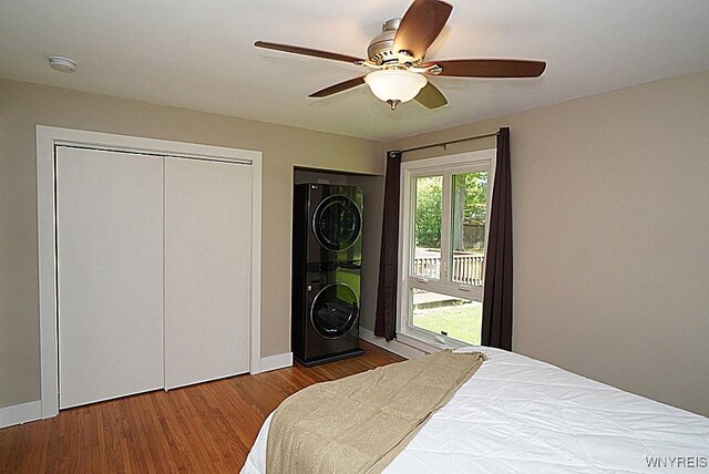 458 Kenwood Dr, Lewiston, NY 14092 - bedroom with stacked washer / drying machine, access to outside, wood finished floors, a ceiling fan, and a closet