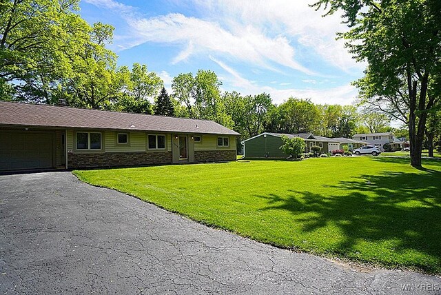 458 Kenwood Dr, Lewiston, NY 14092 - ranch-style home featuring stone siding, a garage, a front yard, and driveway