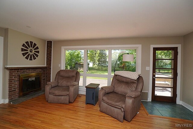 458 Kenwood Dr, Lewiston, NY 14092 - living room with healthy amount of natural light, wood finished floors, a brick fireplace, and baseboards