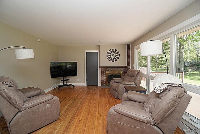 458 Kenwood Dr, Lewiston, NY 14092 - living room featuring wood finished floors, baseboards, and a brick fireplace