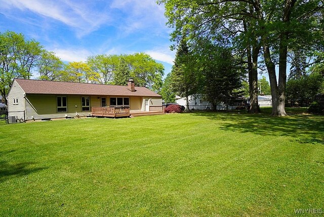 458 Kenwood Dr, Lewiston, NY 14092 - back of house with a chimney, a deck, a lawn, and central AC